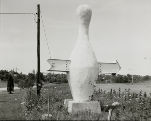Jim Dow, American (born 1942). Bowling Pin with Arrow. US 1, Branford, Connecticut, 1971. Gelatin silver print, 7 7/8 x 9 11/16 inches. Gift of Jim and Jacquie Dow, 2018.55.2