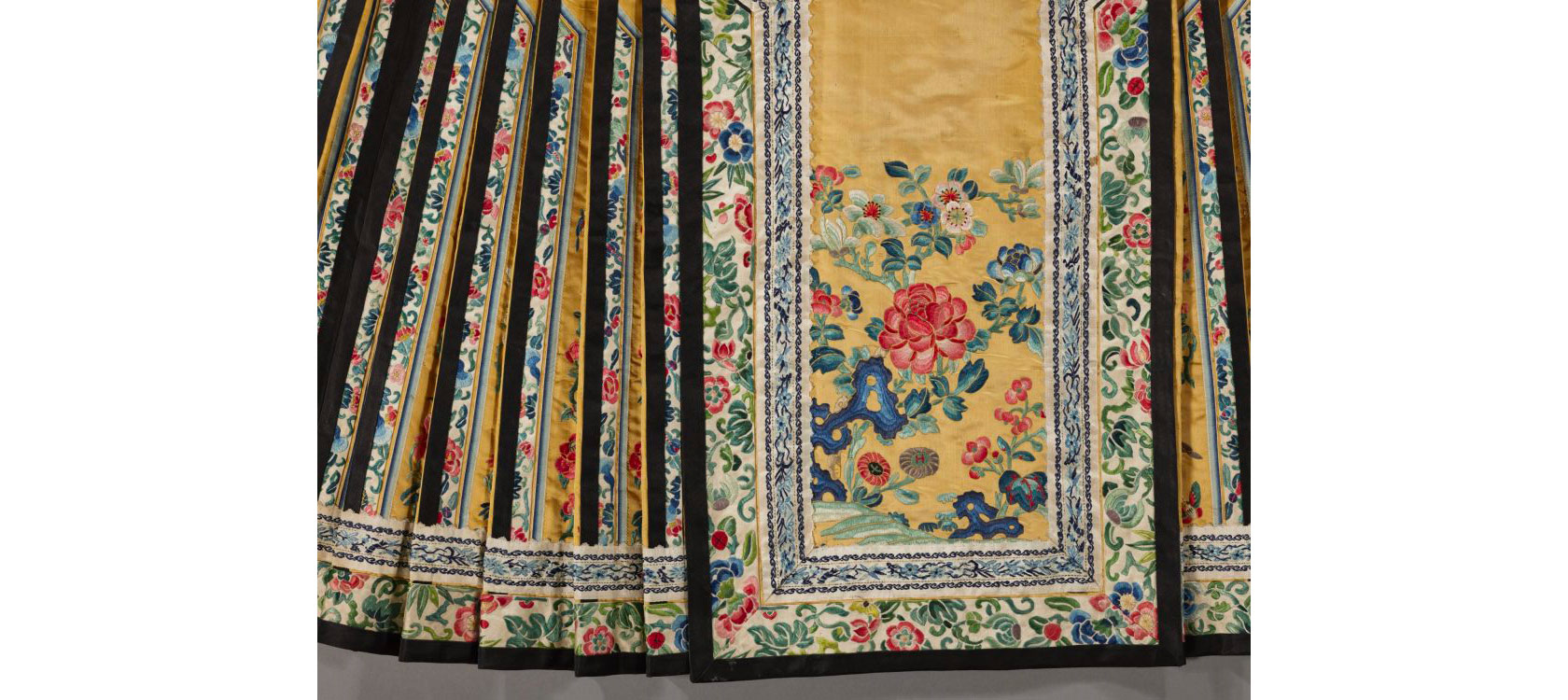 (Detail) Yellow Skirt with Rose Embroidery, China, 19th century. Embroidered satin, 48 inches by 37 3/4 inches. Gift of Mrs. David Beals, 44-63/1.